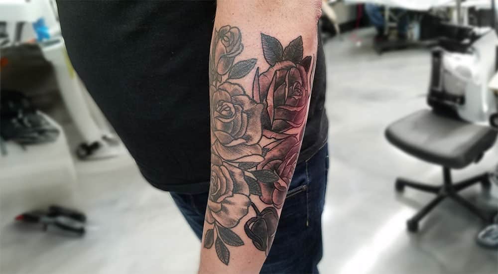 Rose tattoo on a mans forearm
