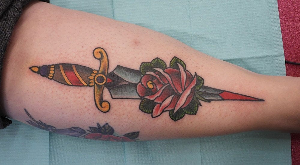 Traditional/Old School tattoo of a dagger and roses